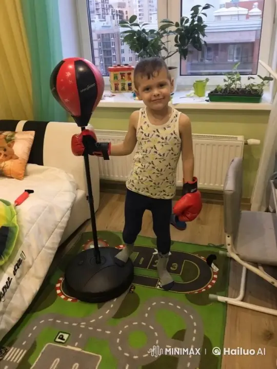 Boy Enthusiastically Punches Boxing Bag in Cozy Room – AI Generated Video | Hailuo AI