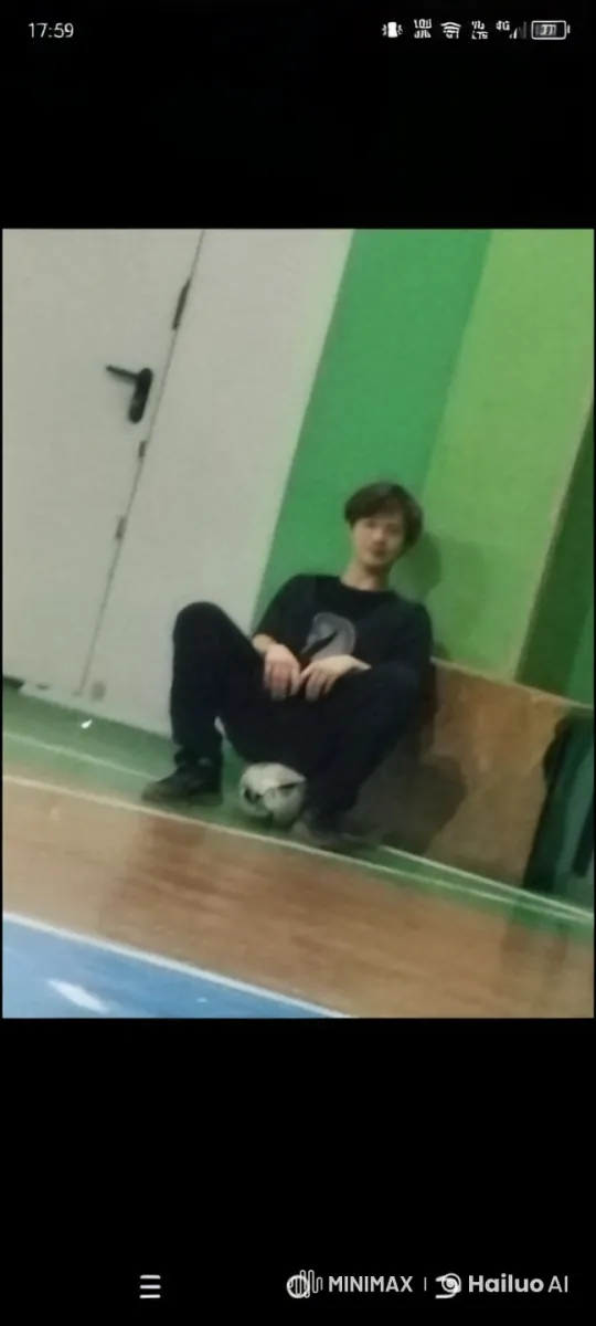 Young Person Resting with Soccer Ball in Indoor Sports Hall – AI Generated Video | Hailuo AI