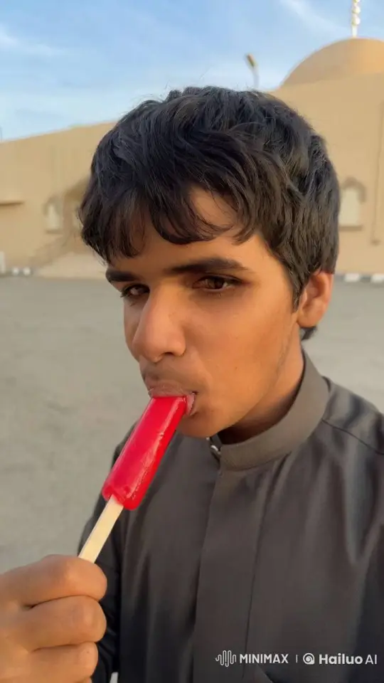 Young Man Savors Red Popsicle on Sunny Day – AI Generated Video | Hailuo AI