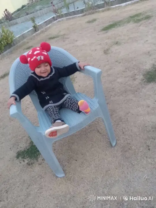 Joyful Child in Plastic Chair Amidst Landscaped Yard – AI Generated Video | Hailuo AI