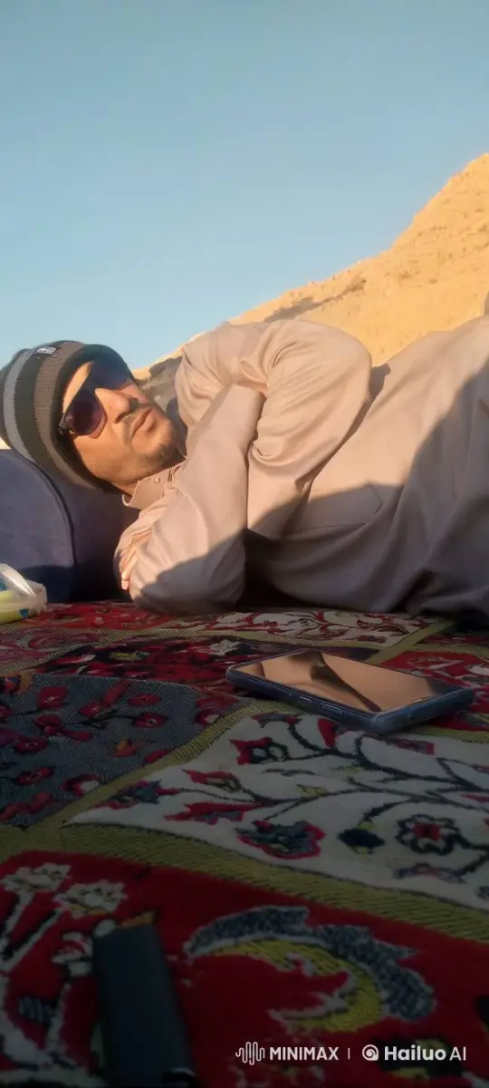 Man Smokes Cigarette on Desert Rug, Enjoying Peaceful Surroundings – AI Generated Video | Hailuo AI