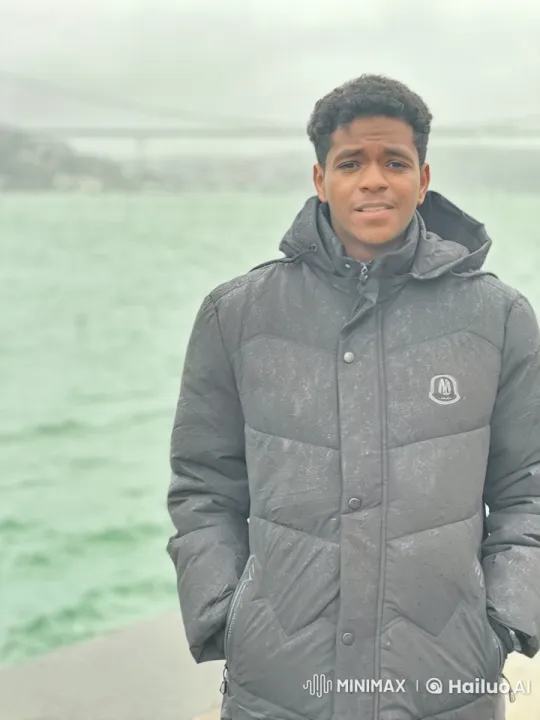 Young Man Smoking by Misty Water with Bridge in Background – AI Generated Video | Hailuo AI