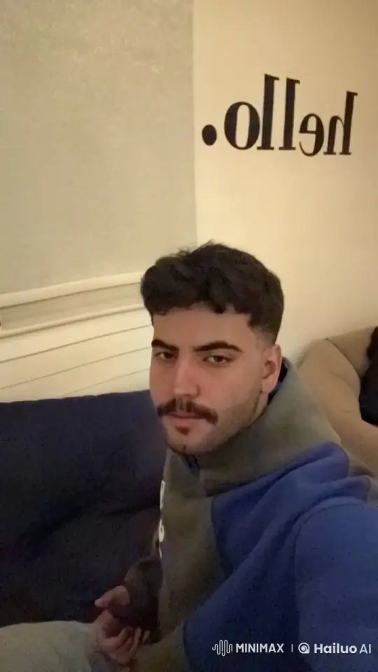 Young Man Smoking on Sofa with Calm Expression – AI Generated Video | Hailuo AI