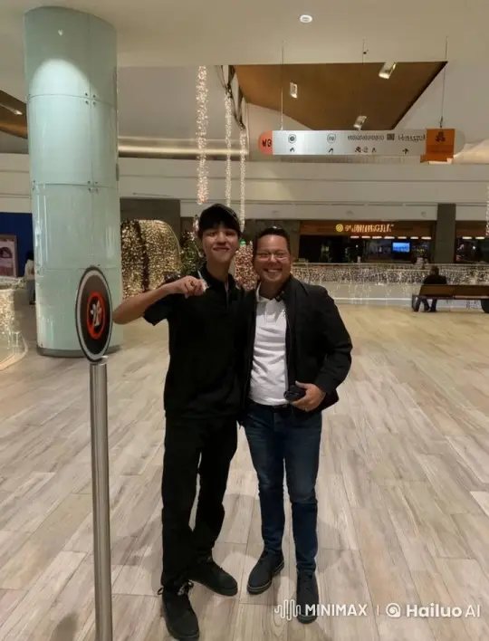 Two Men Share a Friendly Cheek Kiss in a Festive Mall Setting – AI Generated Video | Hailuo AI