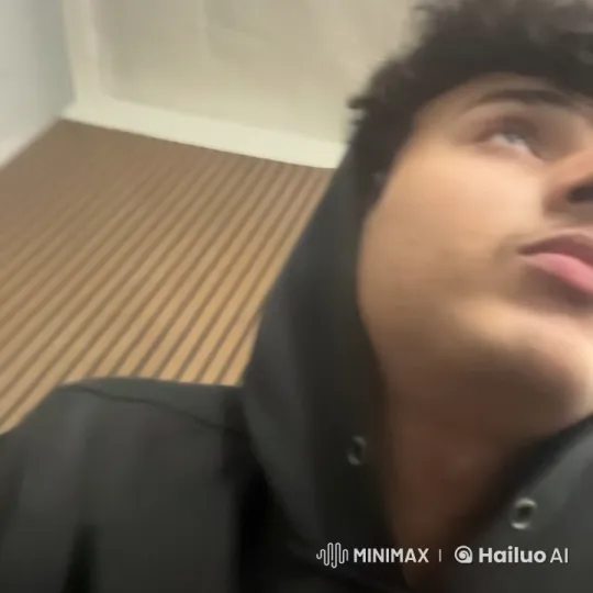 Contemplative Young Man in Black Hoodie Smoking – AI Generated Video | Hailuo AI