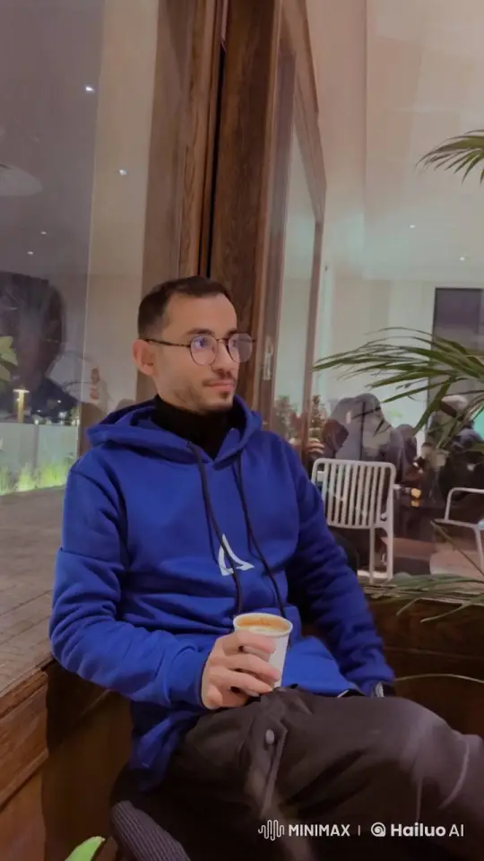 Man in Blue Hoodie Contemplates by Window – AI Generated Video | Hailuo AI