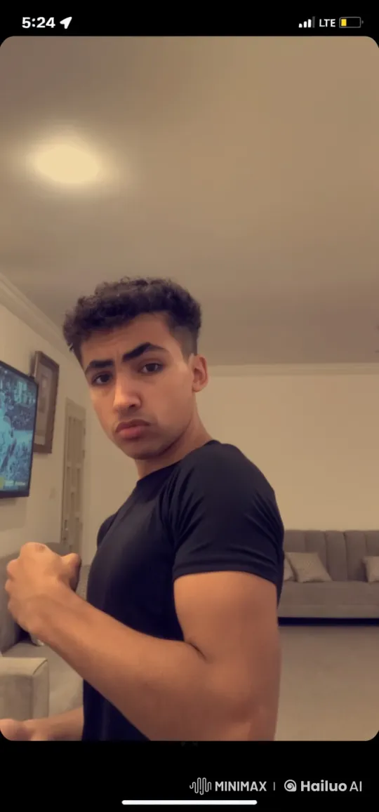 Young Man Flexing Arm with Cigarette in Living Room – AI Generated Video | Hailuo AI