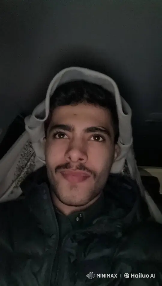 Young Man Contemplates in Dimly Lit Hooded Jacket – AI Generated Video | Hailuo AI