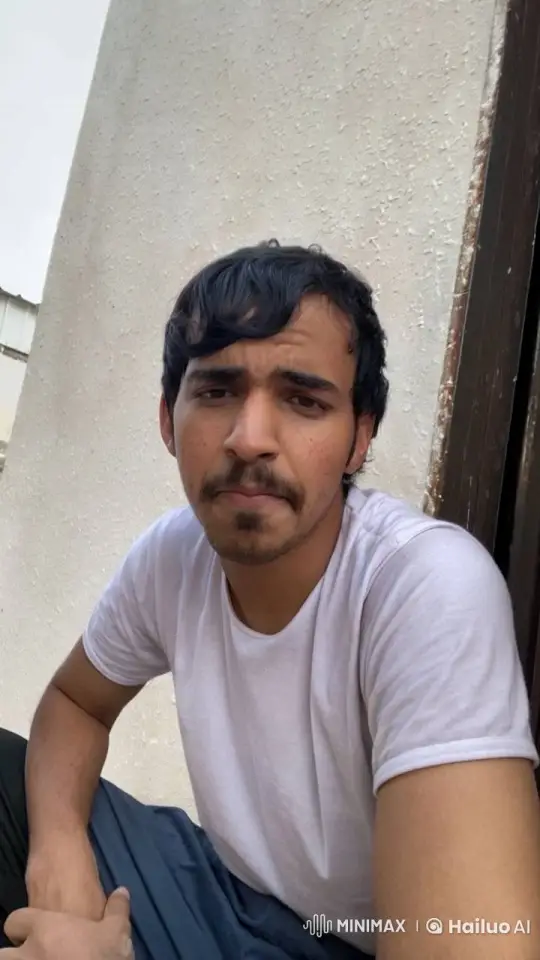 Young Man Contemplatively Smokes by a Wall – AI Generated Video | Hailuo AI