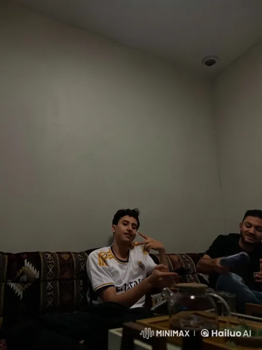 Young Man Smokes and Converses on a Cozy Sofa – AI Generated Video | Hailuo AI