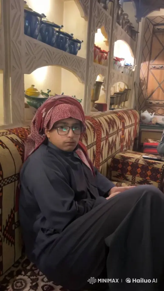Young Man Smokes Pipe in Traditional Attire Amidst Cultural Decor – AI Generated Video | Hailuo AI