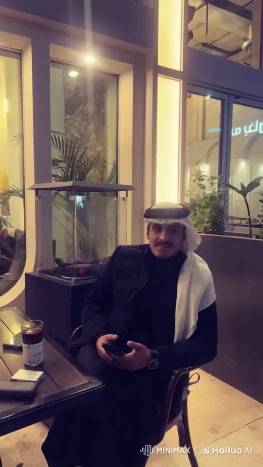 Traditional Attired Man Smokes in Cozy Indoor Café – AI Generated Video | Hailuo AI