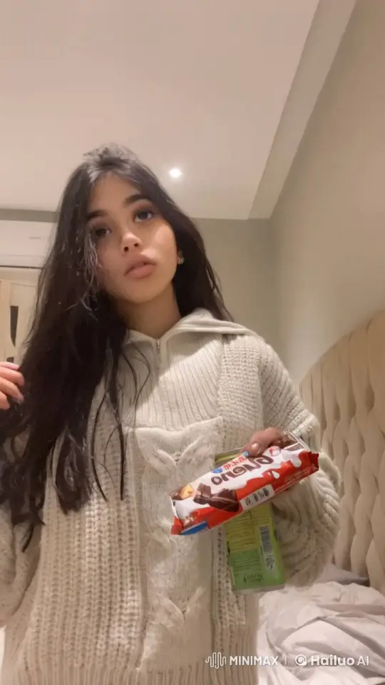 Young Woman in Bedroom Contemplates with Chocolate – AI Generated Video | Hailuo AI