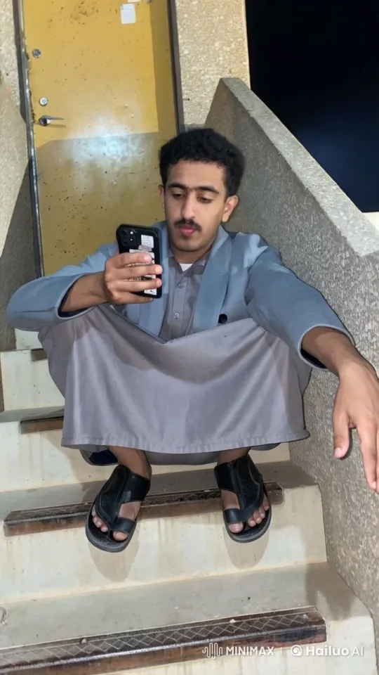 Man Relaxing on Stairs, Smoking and Using Smartphone – AI Generated Video | Hailuo AI