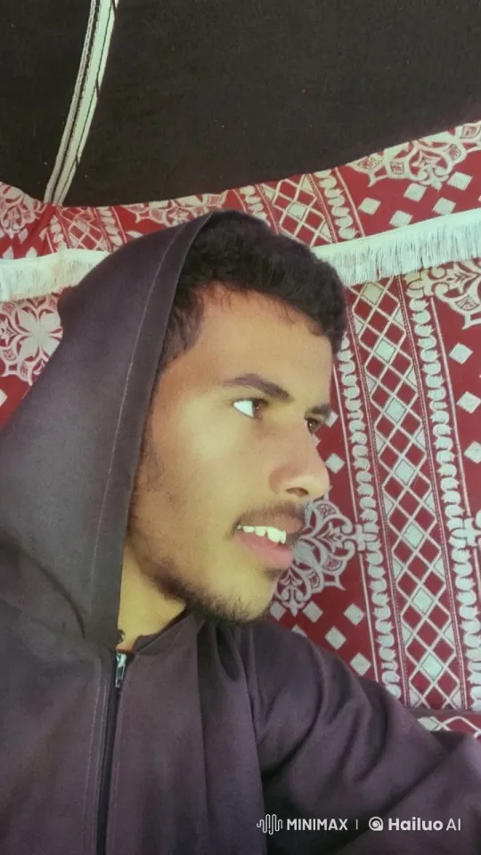 Young Man in Hoodie Smokes in Front of Textile Background – AI Generated Video | Hailuo AI