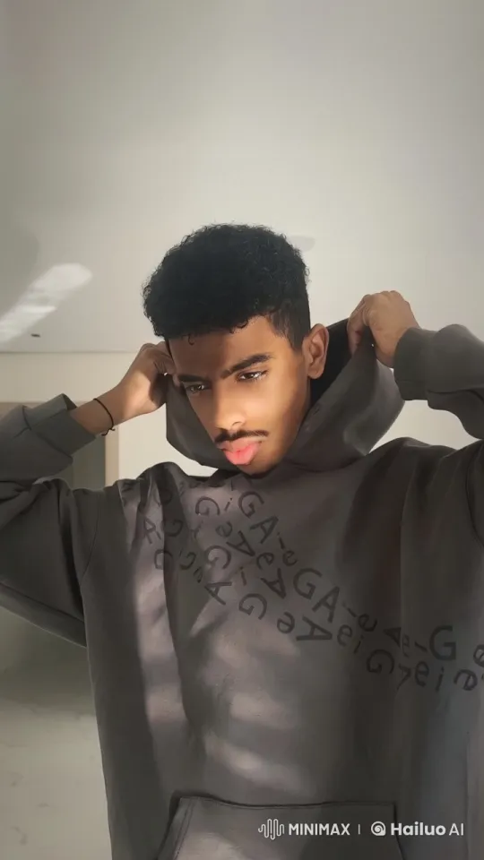 Young Man in Minimalist Room with 'GA GA' Hoodie Smoking – AI Generated Video | Hailuo AI