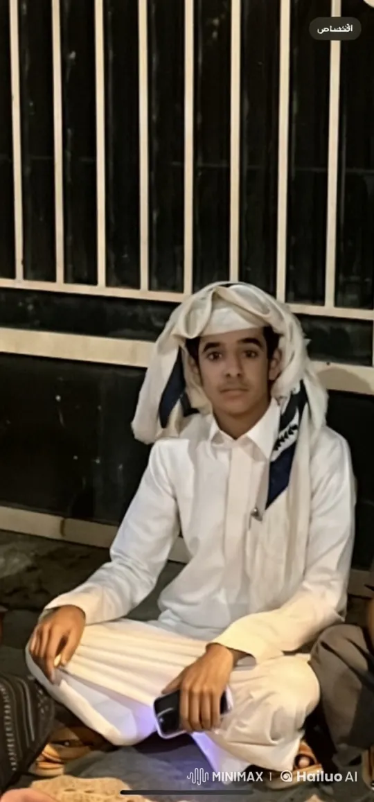 Young Man in Traditional Attire Smoking by a Fence – AI Generated Video | Hailuo AI
