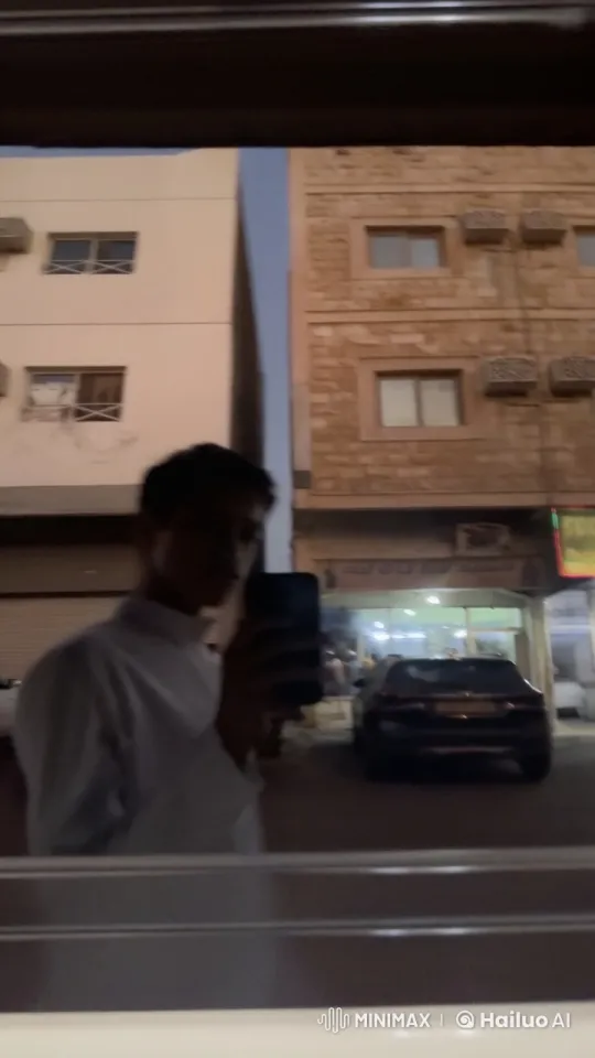 Evening Reflection: Person Smoking by Illuminated Street – AI Generated Video | Hailuo AI