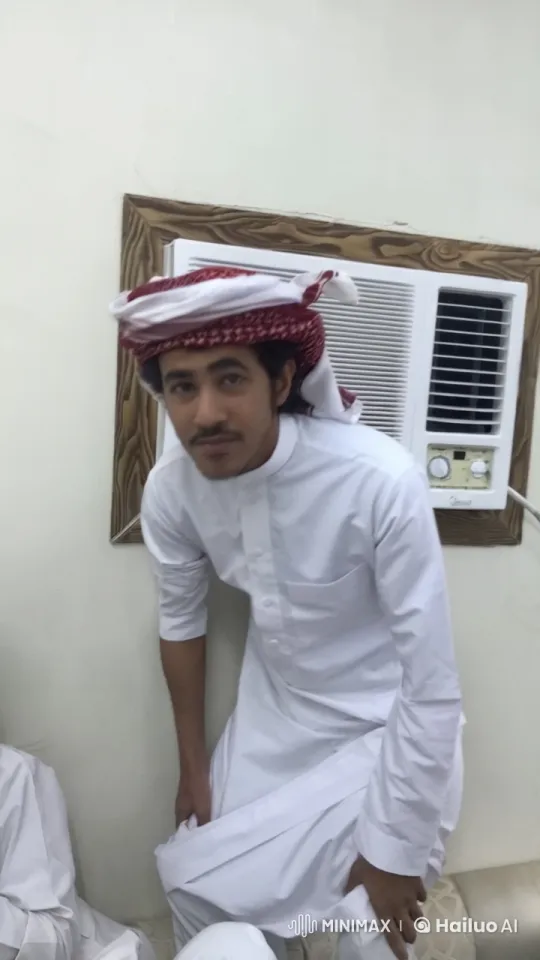 Man in Traditional Attire Smokes by Air Conditioner – AI Generated Video | Hailuo AI