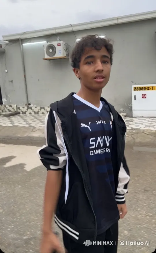 Young Man Smoking by Gray Building in Casual Attire – AI Generated Video | Hailuo AI