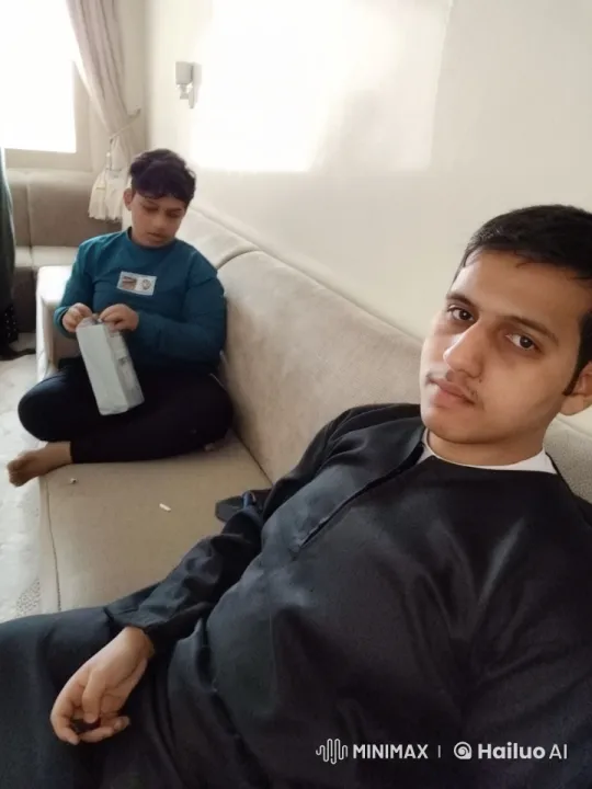Two Individuals on Sofa, One Handling Object – AI Generated Video | Hailuo AI