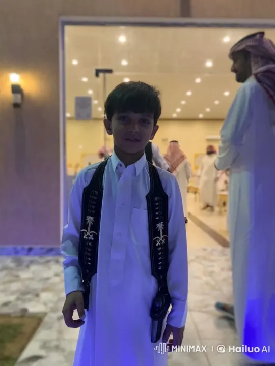 Young Boy in Traditional Attire at Festive Family Gathering – AI Generated Video | Hailuo AI
