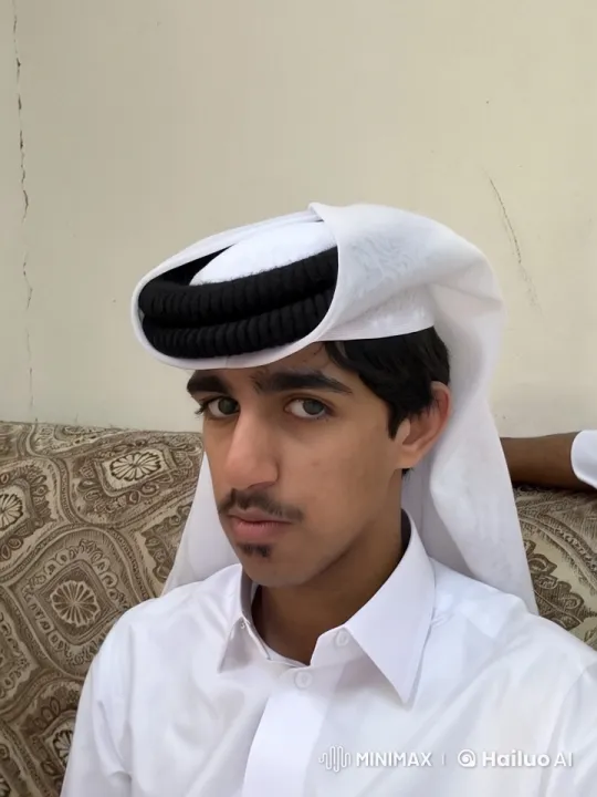 Man in Thobe Smokes Cigarette on Patterned Couch – AI Generated Video | Hailuo AI