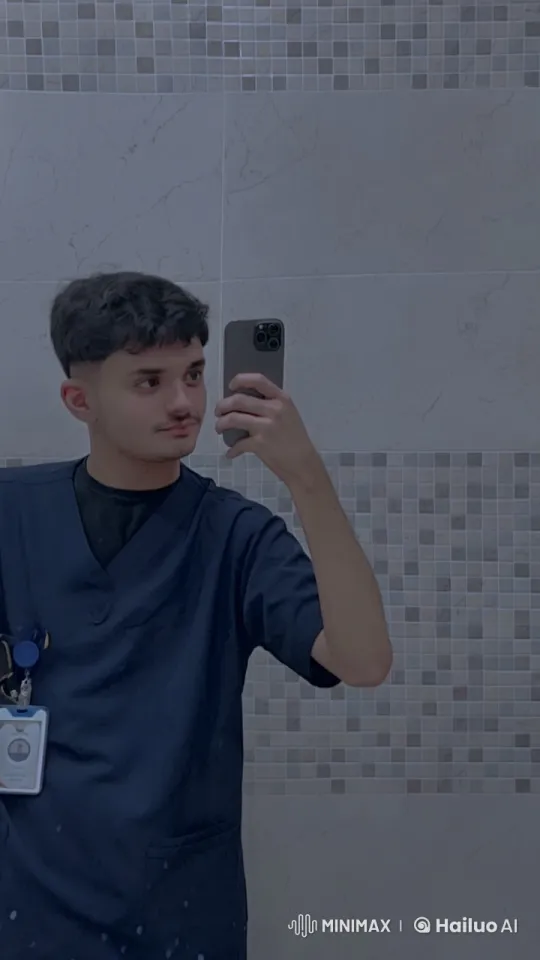 Young Man in Scrubs Takes Selfie Smoking in Bathroom – AI Generated Video | Hailuo AI