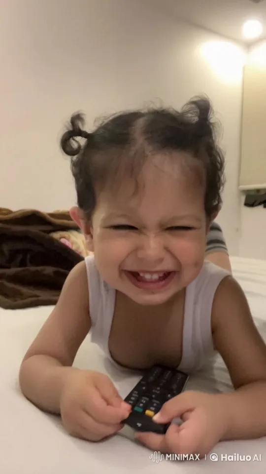Child Curiously Explores TV Remote in Cozy Bedroom – AI Generated Video | Hailuo AI