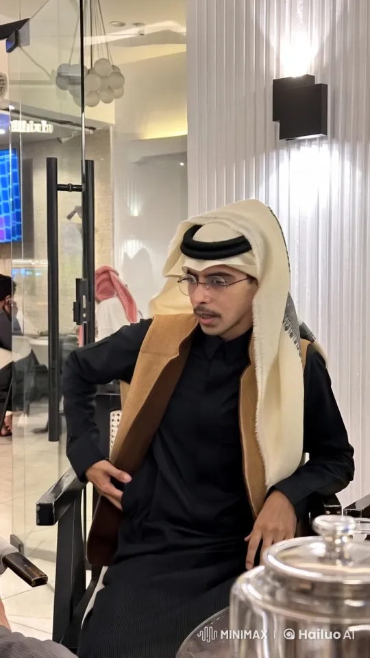 Man in Traditional Attire Smokes in Modern Café – AI Generated Video | Hailuo AI