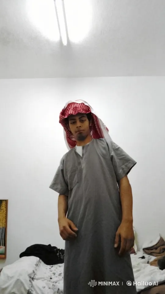 Man Smoking in White-Walled Room with Traditional Attire – AI Generated Video | Hailuo AI