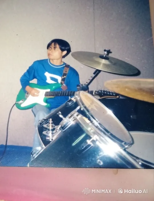 Passionate Musician Playing Green Guitar in Blue Sweater – AI Generated Video | Hailuo AI