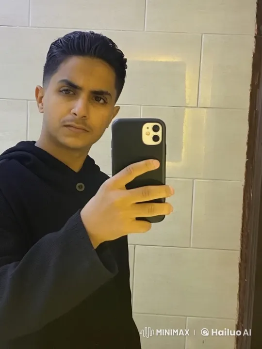 Young Man Taking Selfie in Minimalistic Setting – AI Generated Video | Hailuo AI