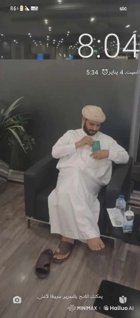 Man Reflects in Modern Lounge with Green Booklet – AI Generated Video | Hailuo AI