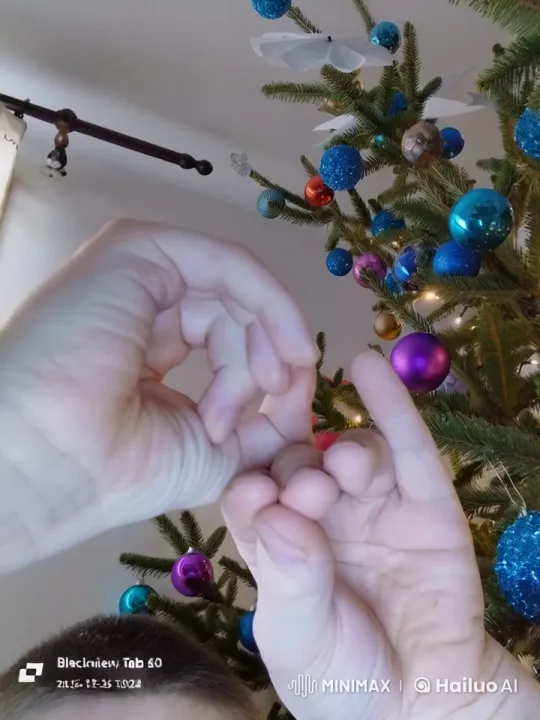 Hands Mimicking Birds Against a Festive Christmas Tree – AI Generated Video | Hailuo AI