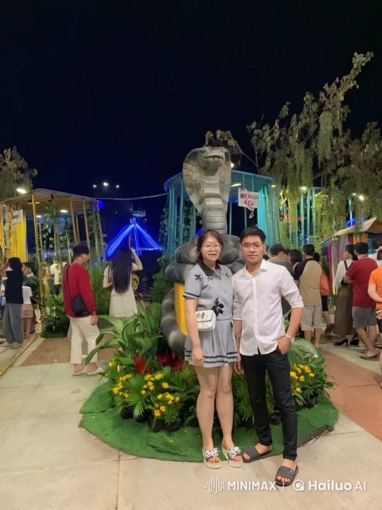 Couple Poses for Photo at Lively Night Attraction – AI Generated Video | Hailuo AI