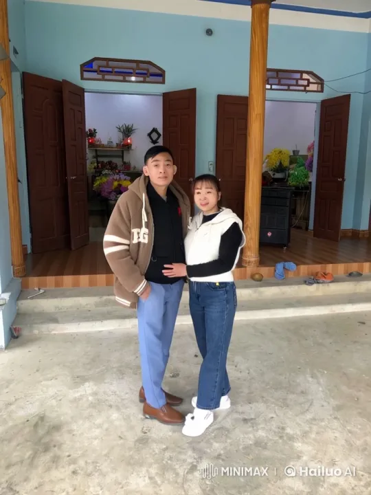 Couple Enjoying Playful Moment at Flower-Filled House Entrance – AI Generated Video | Hailuo AI