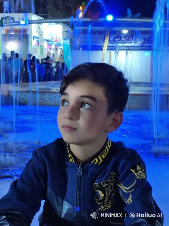 Boy with Lion Jacket Smokes by Vibrant Carnival Fountain – AI Generated Video | Hailuo AI