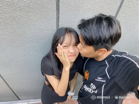 Affectionate Moment Between Young Couple Against Grey Wall – AI Generated Video | Hailuo AI
