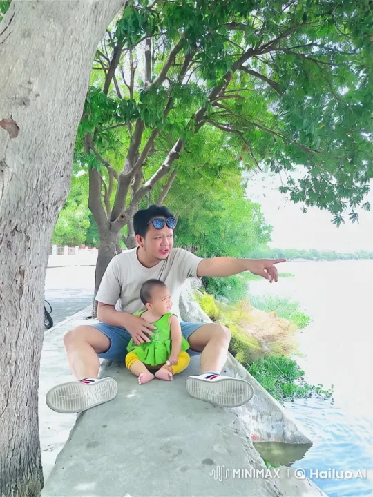Man and Baby Play by Serene Water in Live2D Animation – AI Generated Video | Hailuo AI