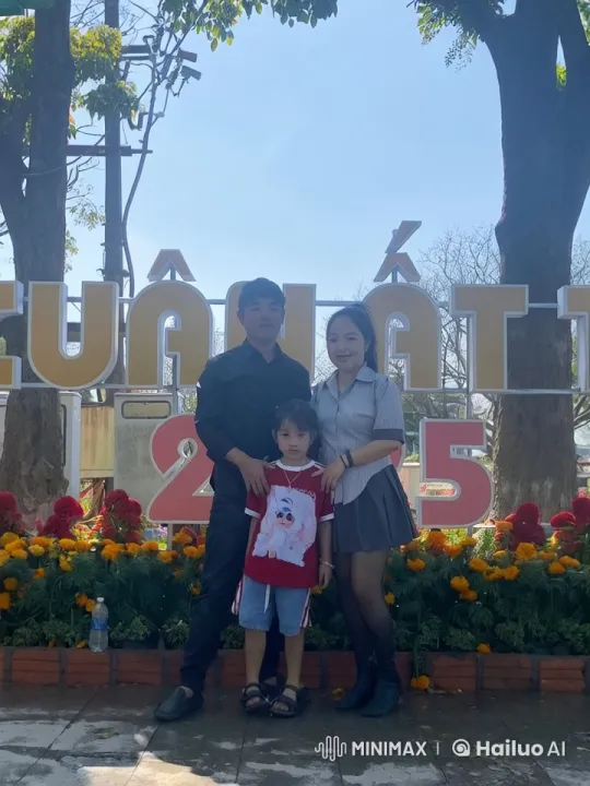 Family Celebrates Event in Front of Floral Sign – AI Generated Video | Hailuo AI