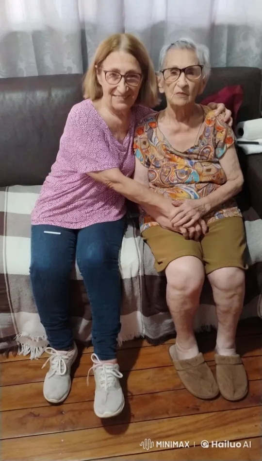 Affectionate Elderly Women Embrace on Sofa – AI Generated Video | Hailuo AI