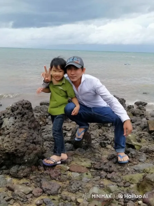 Man and Child Pose Peacefully by Rocky Beach – AI Generated Video | Hailuo AI