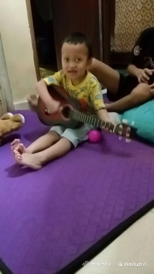 Child Strums Guitar on Purple Mat with Support – AI Generated Video | Hailuo AI