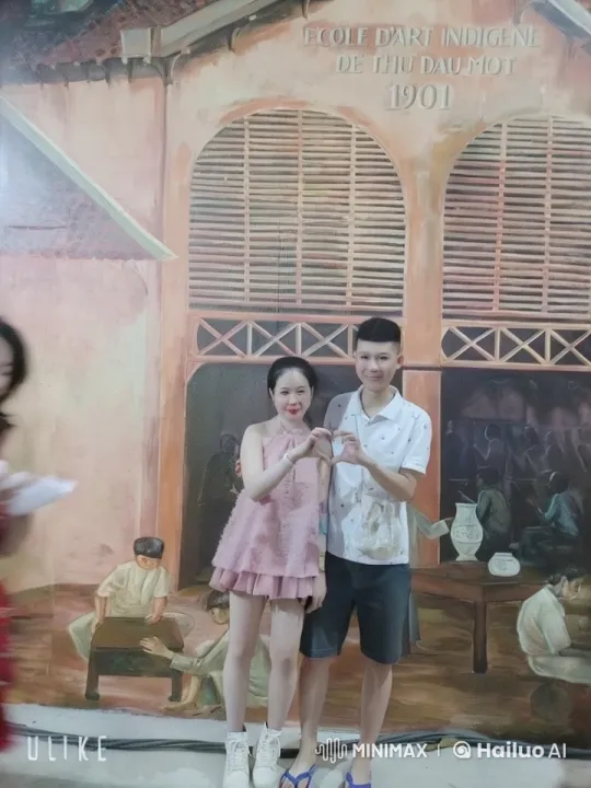 Couple Poses in Front of Historic Mural in Thu Dau Mot – AI Generated Video | Hailuo AI