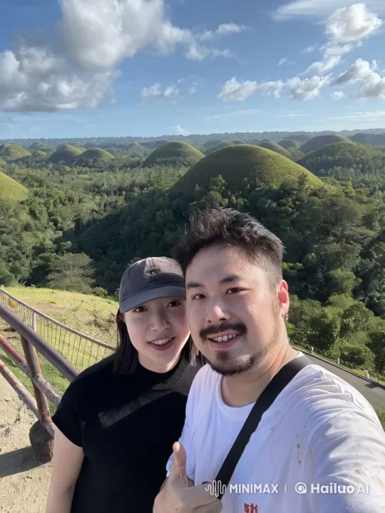 Couple's Playful Tussle and Kiss at Chocolate Hills – AI Generated Video | Hailuo AI