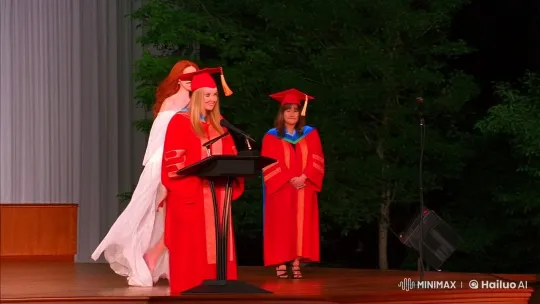 Wind Exposes Gown of Graduating Redhead at Podium – AI Generated Video | Hailuo AI