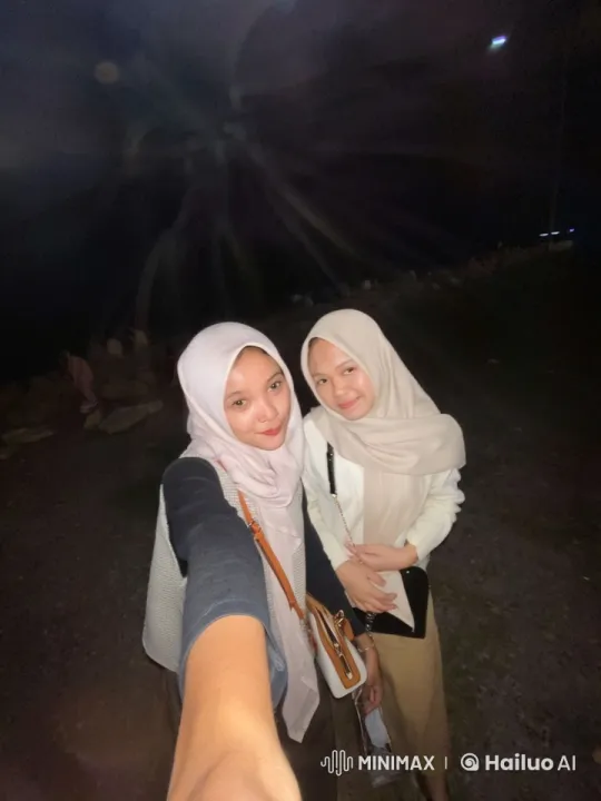 Nighttime Selfie: Two Women in Hijabs Pose – AI Generated Video | Hailuo AI