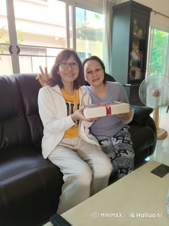 Women Share Joyful Moment with Gift in Cozy Living Room – AI Generated Video | Hailuo AI