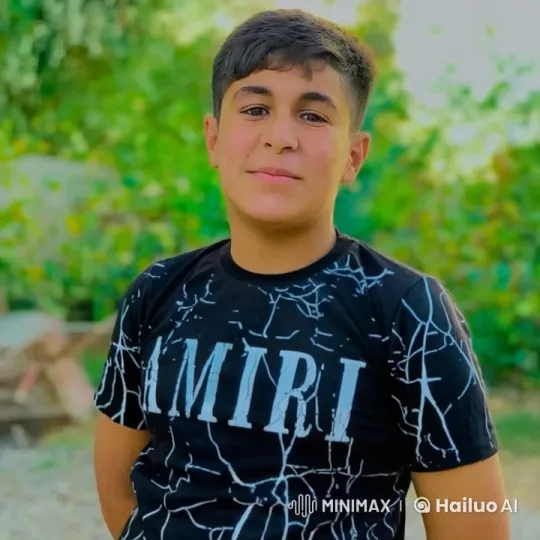 Young Man in AMIRI T-Shirt in Lush Outdoor Setting – AI Generated Video | Hailuo AI
